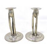 ARCHIBALD KNOX FOR TUDRIC PEWTER AND LIBERTY & CO; a pair of Arts and Crafts candlesticks, the