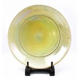 JOHN DUNN (born 1944); a large shallow raku bowl covered in iridescent lime green crackle glaze,