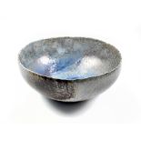 STEPHEN MURFITT (born 1953); a raku open bowl with wavy rim covered in blue glaze with incised