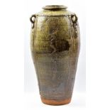 JIM MALONE (born 1946); a tall stoneware lugged vase covered in mottled green ash glaze with incised