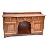 SHAPLAND & PETTER; an Arts and Crafts inlaid oak serpentine fronted sideboard, with three central