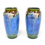 BOURNE DENBY; a pair of Art Nouveau cylindrical vases, with tube lined floral decoration and printed