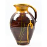 CLIVE BOWEN (born 1943); a slipware jug, honey and green trailed decoration on chestnut ground,