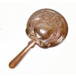 An Arts and Crafts copper dressing table hand mirror, repoussé decorated with two birds and a