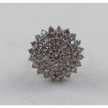 A white metal and diamond stepped cluster ring, approx 10.7g.