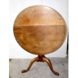 An early 19th century oak and possibly elm tilt-top tripod table, diameter 80cm.