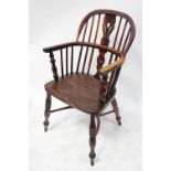 An 18th century elm-seated low-back Windsor armchair with yew wood back and crinoline stretcher.