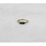 An 18ct gold three-diamond ring, set in white metal claw fitting, marked 18ct,