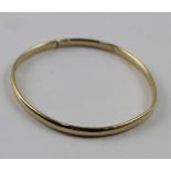 A yellow metal ladies' bangle marked 9K, approx 5g.