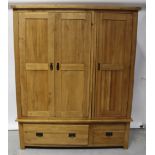 A modern oak bedroom suite comprising light oak triple wardrobe on two-drawer base, height 195cm,