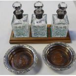 A set of three contemporary cut glass oil bottles with hallmarked silver collars, Birmingham 1988,