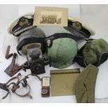 A collection of military items to include framed cap badges, helmets etc.