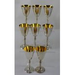 A cased set of eight silver goblets of trumpet form with gilt interiors, on baluster stems,