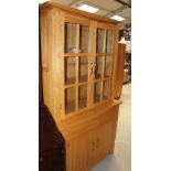 A modern light oak dining room suite comprising display cabinet, dining table,