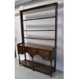 An 18th century oak dresser with plate rack back and three large drawers above two smaller drawers