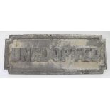 A cast iron Liverpool street sign 'Unadopted' on a painted white background, 23 x 61cm.