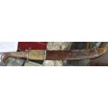 A serrated edged sabre, the steel blade with brass handle,