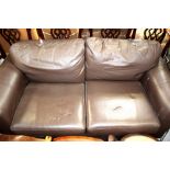 A modern dark brown leather two-seater sofa.