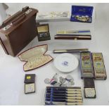 A small brown case containing cutlery, medals and medallions,
