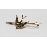 An Edwardian yellow metal bar brooch with swallow set with seed pearls.
