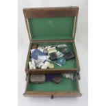 A wooden box containing various costume jewellery and curios to include spoons, fashion watches,