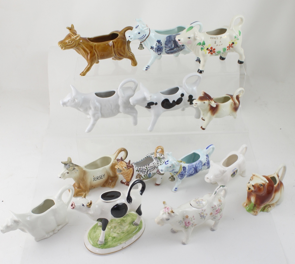 A collection of thirteen modern cow creamer ornaments (13).