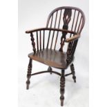 An 18th century elm-seated low-back Windsor armchair with crinoline stretcher.
