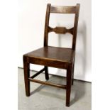 A late 18th/early 19th century oak hall chair on stretchered tapered legs.