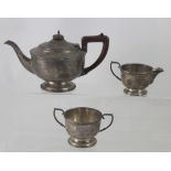 A George V hallmarked silver three-piece tea service comprising teapot, sugar bowl and milk jug,