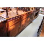 A reproduction Chinese rosewood sideboard with four drawers above four panelled cupboard doors,