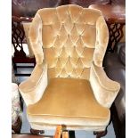 A Georgian-style wing-back armchair with button-back upholstery in a tan-coloured velour,