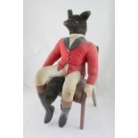 A stuffed fox wearing hunting clothing, seated on bentwood chair.
