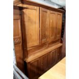 A late 19th/early 20th century large pine kitchen cupboard with two twin-panel cabinets to the top