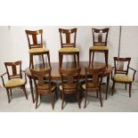 A yew and walnut inlaid extending oval dining table to tapering supports,