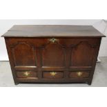 An 18th century oak coffer with panelled front above three base drawers, length 130cm.