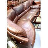 A brown leather four-seater corner settee.