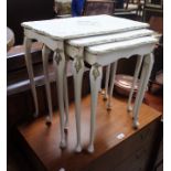 A nest of cream painted French-style tables,