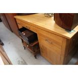 A modern light oak kneehole desk,
