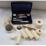 A 1920s carved ivory dressing table set comprising vanity jars, hat pin jar, ring tree,