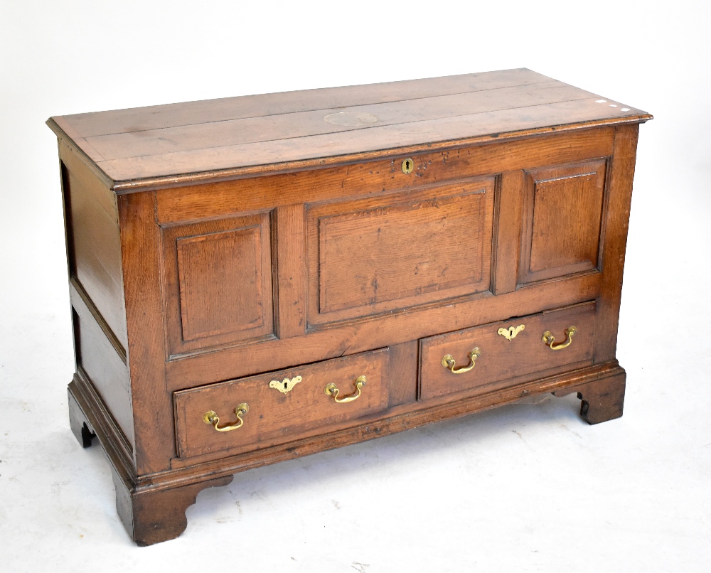 An 18th century oak coffer, with panelled decoration to front above two base drawers, raised on