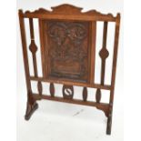 An Arts and Crafts carved oak fire screen, the central panel carved with oak leaves, height 92cm.