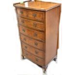 A reproduction walnut chest of drawers in the form of a small tallboy.
