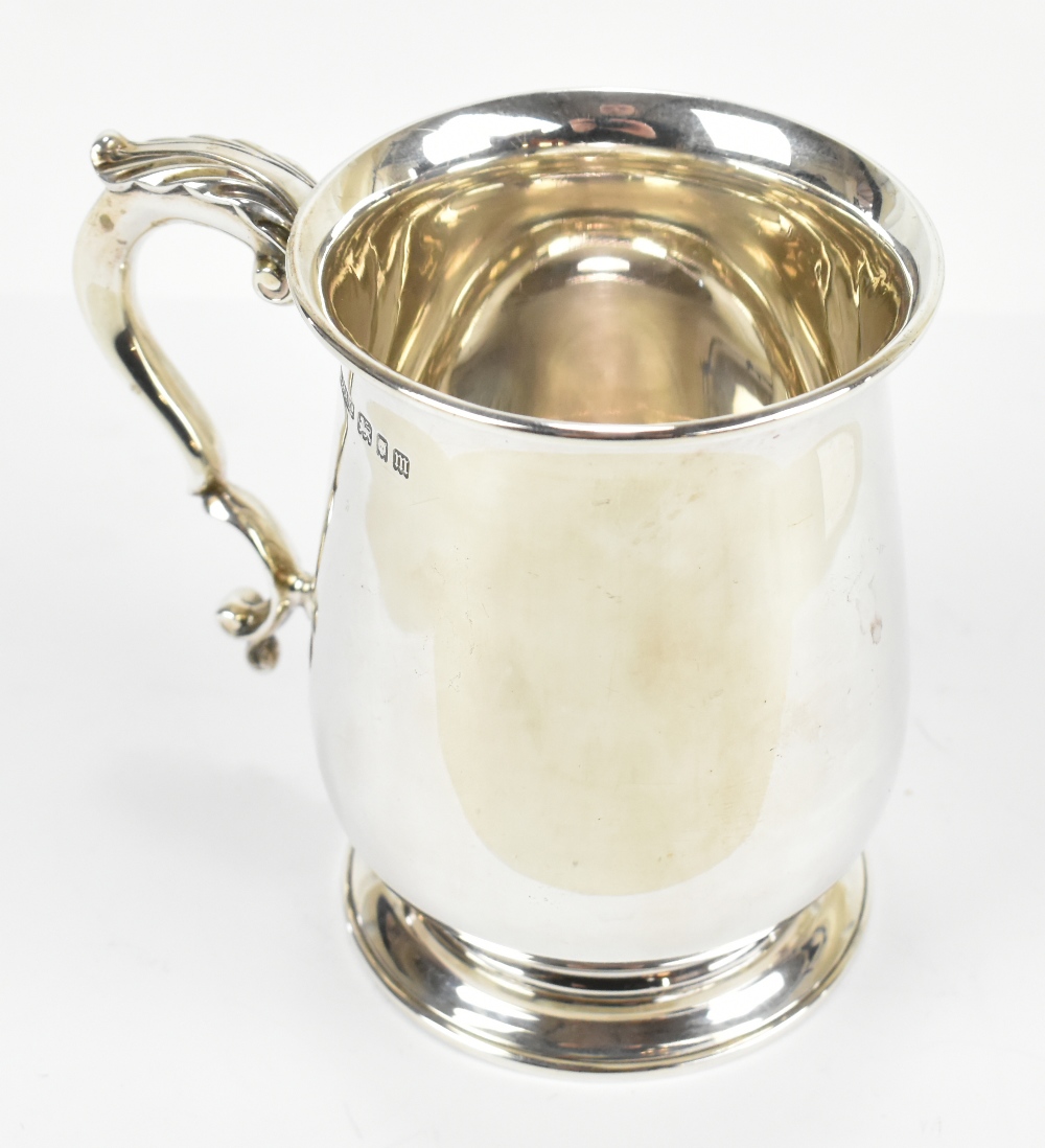 ASPREY; a George V hallmarked silver mug, with loop handles and spreading circular foot, London