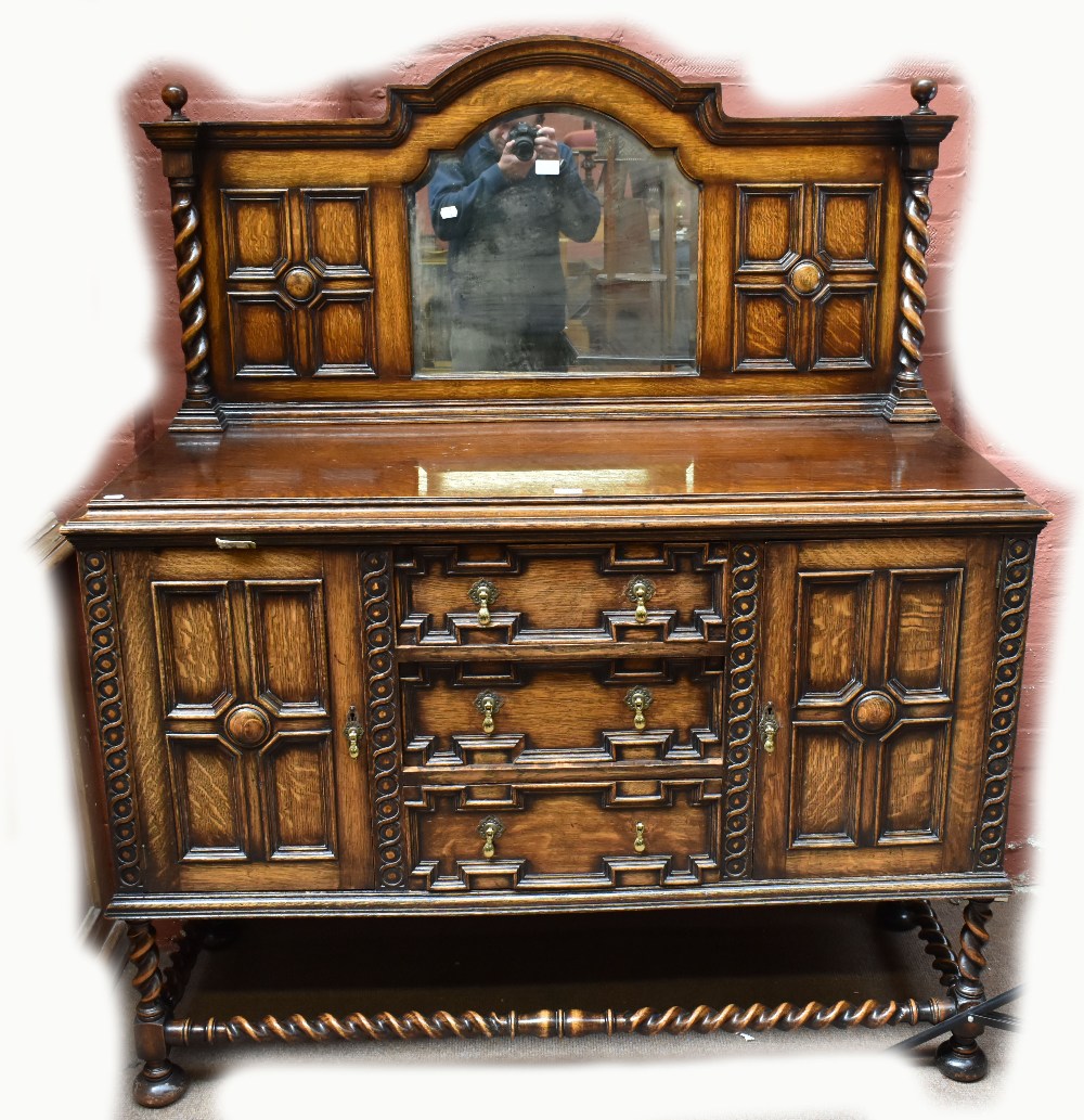 An early 20th century oak dining suite comprising a table, sideboard and set of chairs.