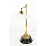 A brass Victorian style table lamp with glass floral shade on raised circular wooden base, height
