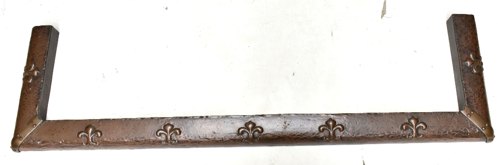 An Arts and Crafts copper fender relief decorated with fleur de lis, length 137cm.