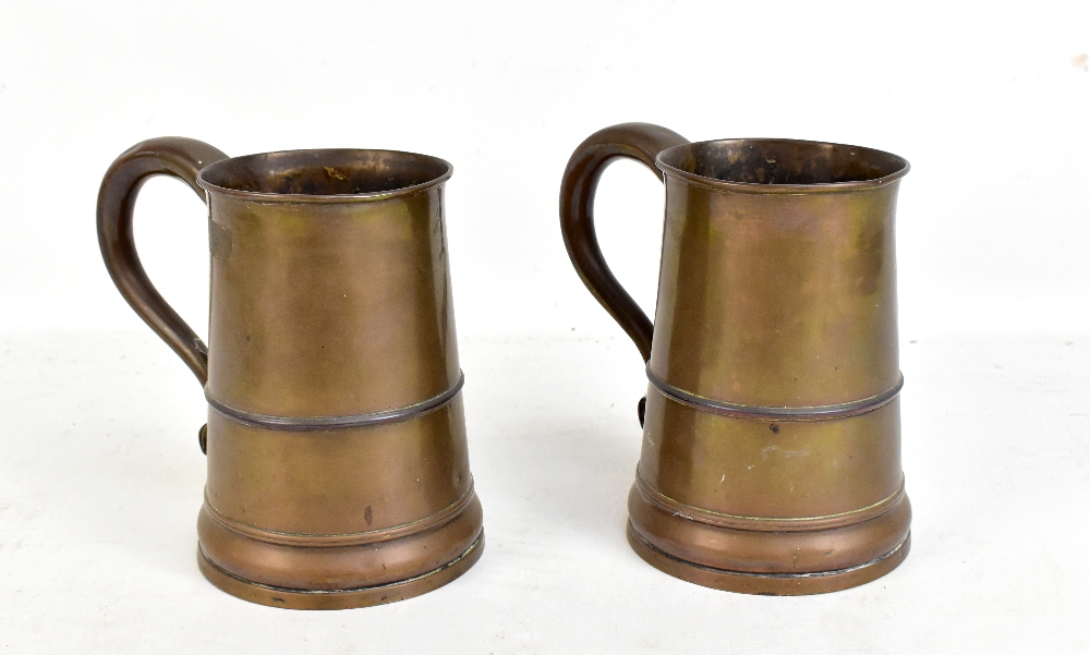 A pair of early 19th century copper mugs with loop handles, scrolling thumbpiece and tapering