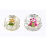 PERTHSHIRE; two clear faceted glass paperweights, each encased with mini flowers, each signed,