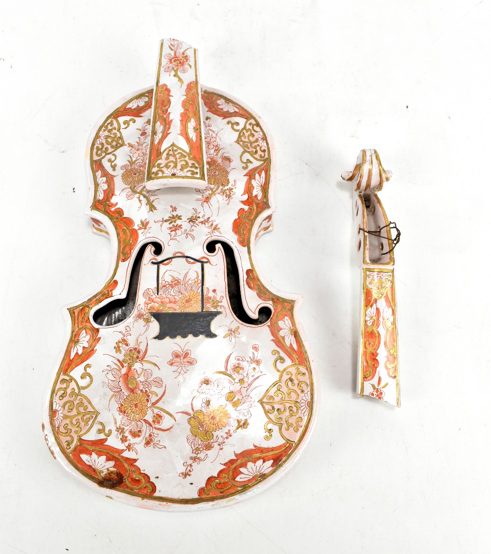 An unusual 19th century continental tin glazed model of a violin, life sized and decorated in the