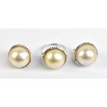 A white metal dress ring set with a pearl, and a matching pair of white metal earrings stamped